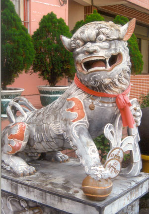 A fierce lion in front of a Buddhist Temple.