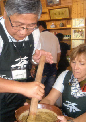 Thomas Shu (tour leader) and my friend Lisa, while using a large mortar and pestle, grind the peanuts, pine nuts, white and black sesame seeds, pumpkin & sunflower seeds, and dried tea leave into a paste. A dollop of the paste is then put into a cup to which brewed green tea was added. This makes a very nutritious and flavorful porridge-like brew.